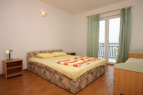 a bedroom with a bed and a balcony at Apartments with a parking space Zivogosce - Porat, Makarska - 6700 in Igrane