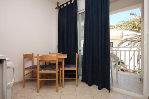 a dining room with a table and chairs and a window at Apartments by the sea Drvenik Donja vala, Makarska - 6756 in Drvenik