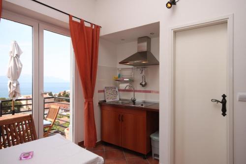 a kitchen with a view of a balcony at Apartments by the sea Gradac, Makarska - 6661 in Gradac