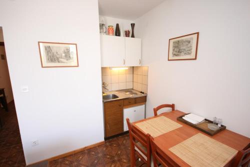 a kitchen and dining room with a table and a sink at Apartments by the sea Mandre, Pag - 6474 in Mandre