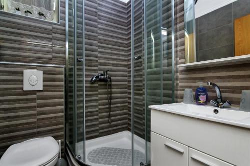 a bathroom with a shower and a toilet and a sink at Apartments with a parking space Makarska - 6909 in Makarska