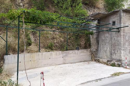an empty parking lot with a green metal structure at Apartments by the sea Podgora, Makarska - 6789 in Podgora
