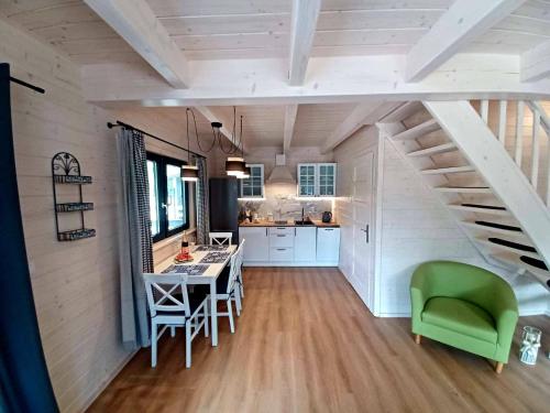 a kitchen and dining room with a staircase in a tiny house at Siemianówka in Siemiany