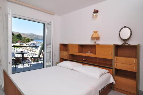a bedroom with a bed and a view of the ocean at Apartments by the sea Seget Vranjica, Trogir - 6597 in Seget Vranjica