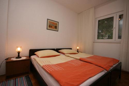 a bedroom with a bed with two lamps on it at Apartments by the sea Mandre, Pag - 6515 in Kolan