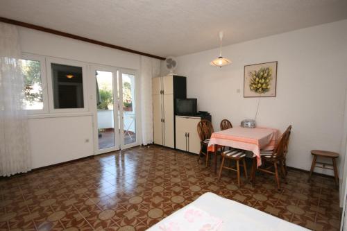 a dining room with a table and a refrigerator at Apartments by the sea Mandre, Pag - 6515 in Kolan