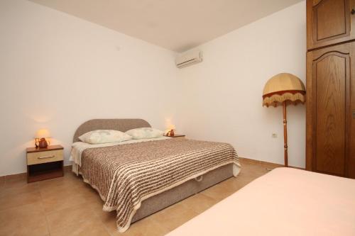 a bedroom with a bed with two lamps on it at Apartments with a parking space Makarska - 6792 in Makarska