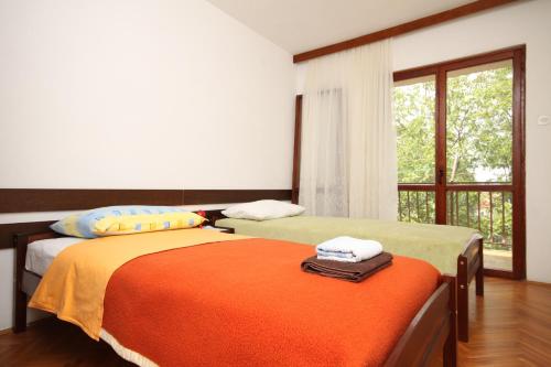 two beds in a room with a window at Apartments by the sea Starigrad, Paklenica - 6626 in Starigrad