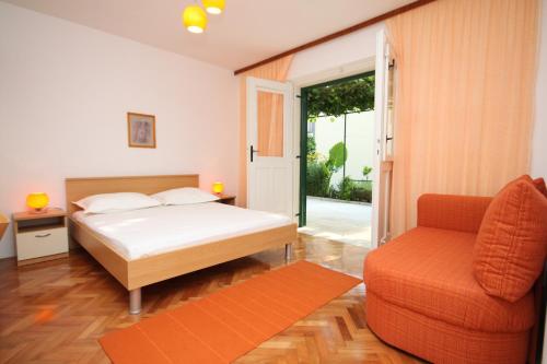 a bedroom with a bed and a couch and a chair at Apartments by the sea Podgora, Makarska - 6664 in Podgora