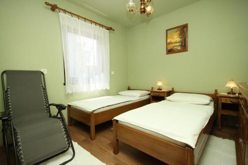 - une chambre avec deux lits, une chaise et une fenêtre dans l'établissement Apartments with a parking space Starigrad, Paklenica - 6566, à Starigrad-Paklenica