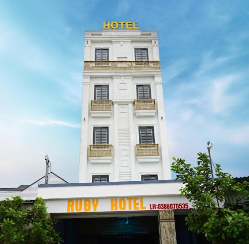 ein weißes Gebäude mit einem Hotelschild darüber in der Unterkunft Ruby Hotel - Tân Uyên - Bình Dương in Hoi Nghia