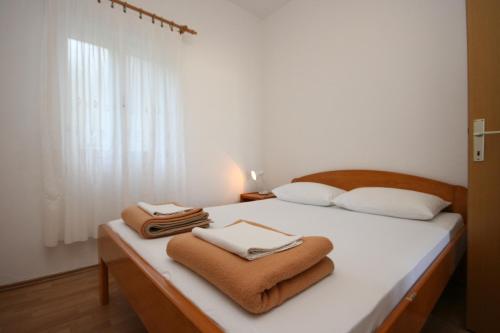 a bedroom with a bed with towels on it at Apartments with a parking space Gradac, Makarska - 6724 in Gradac