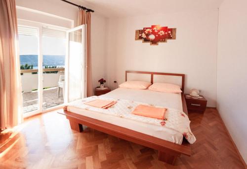 sypialnia z łóżkiem i dużym oknem w obiekcie Apartments by the sea Pag - 6448 w mieście Pag