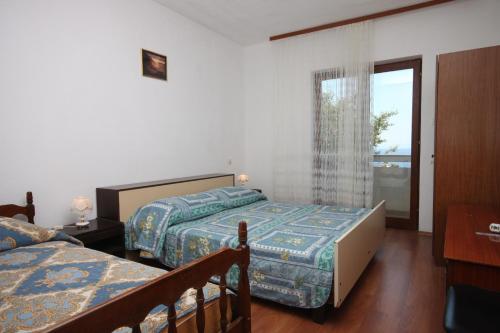 een slaapkamer met 2 bedden en een raam bij Apartments by the sea Lun, Pag - 6450 in Lun