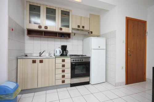 een keuken met een fornuis en een koelkast bij Apartments by the sea Lun, Pag - 6450 in Lun