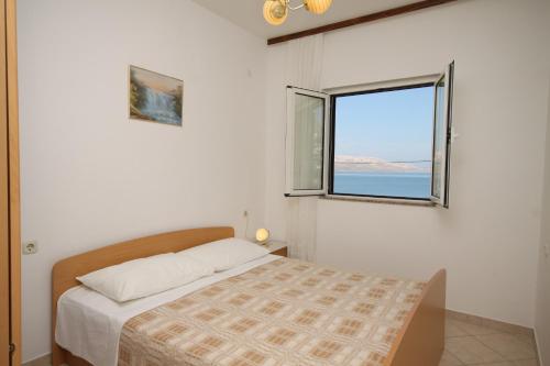 Habitación blanca con cama y ventana en Apartments by the sea Metajna, Pag - 6486, en Metajna