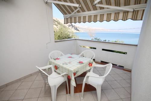 una mesa y sillas en un balcón con vistas al océano en Apartments by the sea Metajna, Pag - 6486, en Metajna