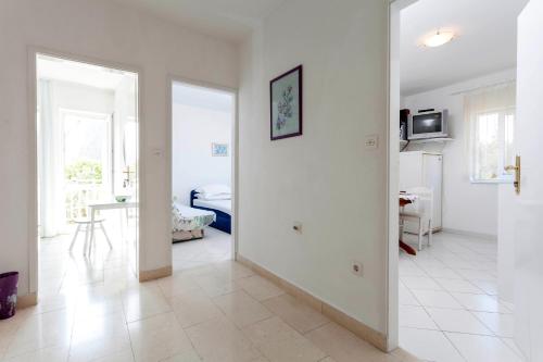 a white room with a bedroom and a bed at Apartments by the sea Podgora, Makarska - 6671 in Podgora