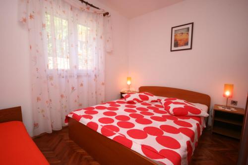 1 cama roja y blanca en una habitación con ventana en Apartments by the sea Slatine, Ciovo - 6888 en Trogir