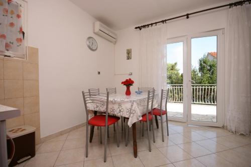 comedor con mesa y sillas y balcón en Apartments by the sea Slatine, Ciovo - 6888 en Trogir