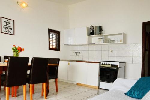 uma cozinha com uma mesa, cadeiras e um fogão em Apartments by the sea Pirovac, Sibenik - 6447 em Pirovac