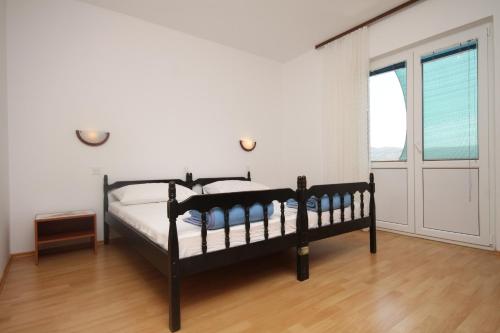 a bedroom with a bed and a large window at Apartments with a parking space Zubovici, Pag - 6520 in Zubovići