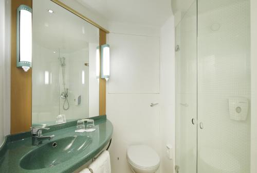 a bathroom with a green sink and a toilet at Ibis Madrid Fuenlabrada in Fuenlabrada