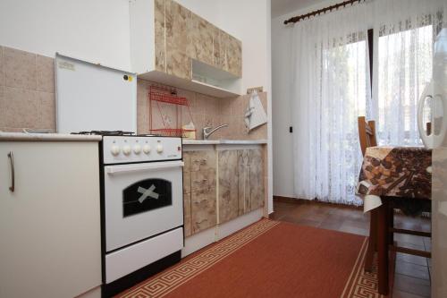 a kitchen with a white stove top oven next to a window at Apartments and rooms by the sea Starigrad, Paklenica - 6591 in Starigrad