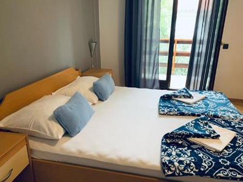 a bed with blue and white pillows on it at Apartments and rooms by the sea Starigrad, Paklenica - 6591 in Starigrad