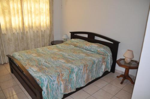 sypialnia z łóżkiem i stołem z lampką w obiekcie La Colombe D'Or w mieście Grand'Anse Praslin
