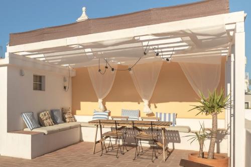 a patio with a table and chairs and a couch at Casa ao Cubo in Olhão