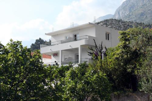 a white building on top of a hill with trees at Apartments by the sea Drvenik Donja vala, Makarska - 6701 in Drvenik