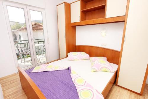 ein kleines Schlafzimmer mit einem Bett und einem Fenster in der Unterkunft Apartments by the sea Drvenik Donja vala, Makarska - 6701 in Drvenik