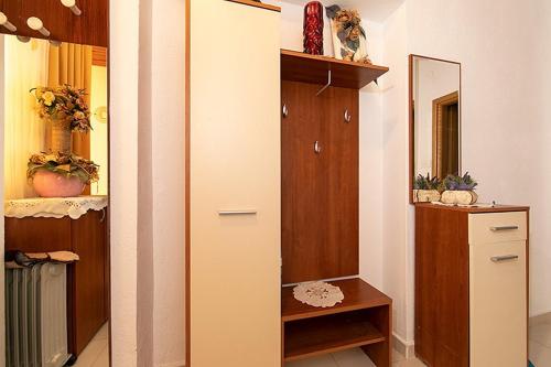 a closet with a mirror and a wooden cabinet at Apartments with a parking space Tucepi, Makarska - 6695 in Tučepi