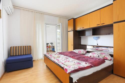 トゥチェピにあるApartments with a parking space Tucepi, Makarska - 6695のベッドルーム(大型ベッド1台、青い椅子付)