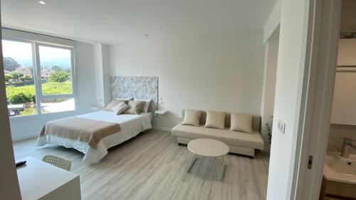 a bedroom with a bed and a couch and a window at Camiño da Praia in Redondela