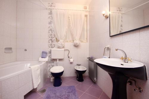 La salle de bains est pourvue d'un lavabo, d'une baignoire et de toilettes. dans l'établissement Apartments and rooms with parking space Makarska - 6767, à Makarska