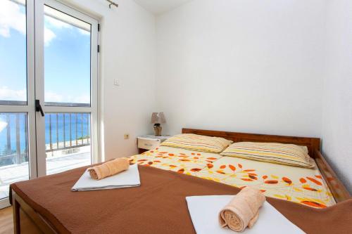 - une chambre avec un lit et une grande fenêtre dans l'établissement Apartments with a parking space Baska Voda, Makarska - 6761, à Baška Voda