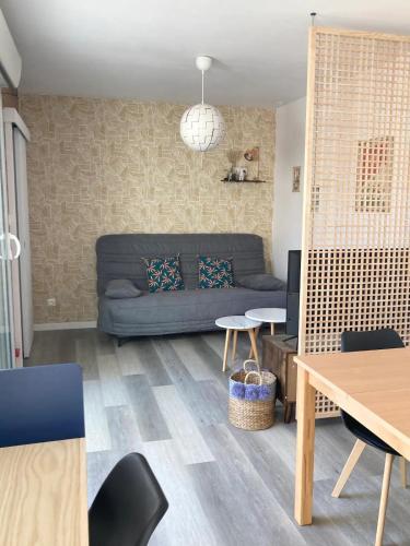 un salon avec un canapé et une table dans l'établissement LA PETITE MAISON TAHET, 2 pers avec terrasse, à Basse-Indre