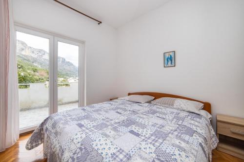 a bedroom with a bed and a large window at Apartments by the sea Podaca, Makarska - 6735 in Podaca