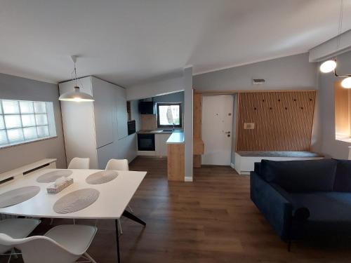 un soggiorno con tavolo bianco e divano blu di Lovely Apartment Ioana a Târgu Neamț
