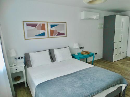 1 dormitorio con cama y mesa azul en Apartamento único en El Sauzal - inolvidable!!!, en Sauzal