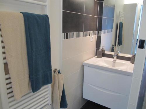 une salle de bain blanche avec un lavabo et un miroir dans l'établissement BIDART CENTRE et PLAGE A PIED, à Bidart