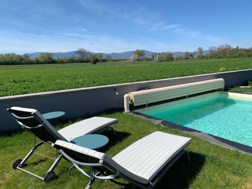 - deux chaises et une piscine avec un banc dans l'établissement CHAMBRE D'HOTES DANS MAISON PROCHE de COLMAR, à Holtzwihr