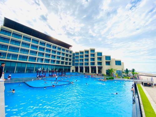 a large swimming pool in front of a building at Mường Thanh Luxury Xuân Thành in Ha Tinh