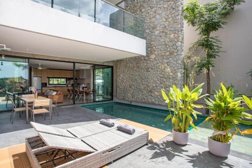 an indoor swimming pool in a house with plants at Villa Jeanne in Kamala Beach