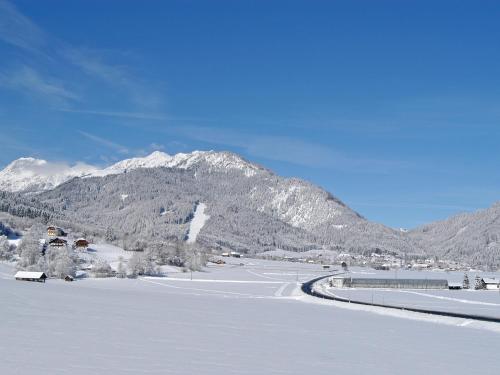 a snow covered valley with a mountain in the background at Hotel Brunnwirt in Weissbriach