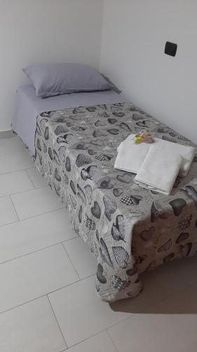 een bed met een zwart-witte deken erop bij Casa vacanza il fiore in Castelbuono