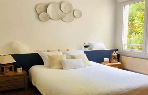 a bedroom with a large bed with white sheets and pillows at "BELLEVUE" Magnifique appartement vue sur mer et face à Nausicàa in Boulogne-sur-Mer