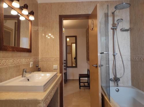 a bathroom with a sink and a shower and a tub at Apartamento Ferrera Park 607 in Cala Ferrera